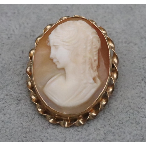 601 - An oval cameo brooch in 9ct gold mount with twist ring (slight crack to cameo), 2.3cm high, 5.9 gram... 