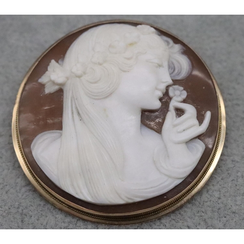 610 - A circular cameo pendant/brooch with figurehead of a lady smelling a flower in 18ct gold frame, 4.5c... 