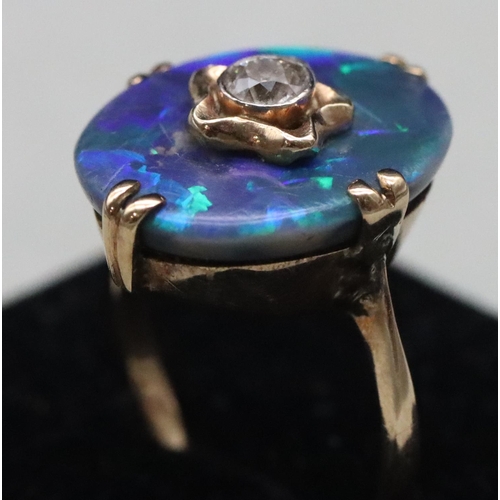 614 - An oval black opal ladies' ring set with centre diamond (Approx. 0.20ct), Size M/N, 3.9 grams gross