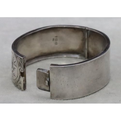 644 - A Birmingham silver wide band hinged bangle with engraved bird, floral and scroll decoration, 24.3 g... 