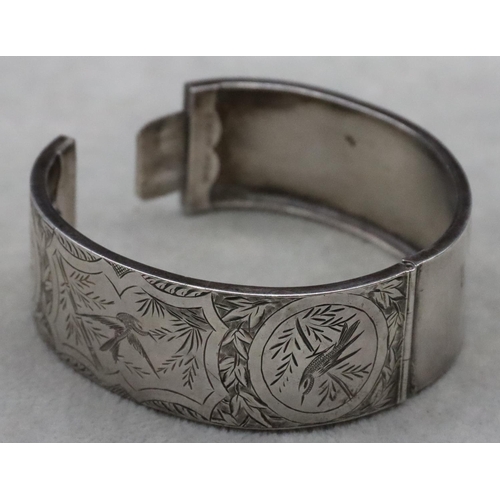 644 - A Birmingham silver wide band hinged bangle with engraved bird, floral and scroll decoration, 24.3 g... 