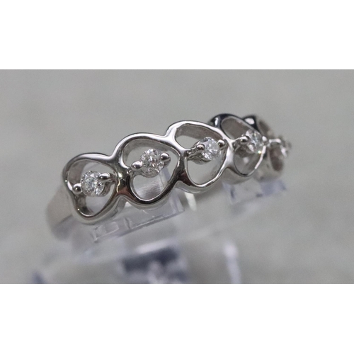 657 - A 9ct white gold ladies' ring set with 5 small diamonds in heart shaped mounts, Size N/O, 2.5 grams ... 