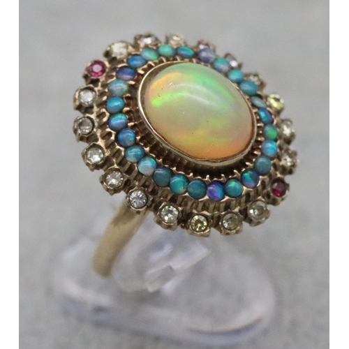 667 - A 14ct gold ladies' oval cluster ring set with centre opal surrounded by furthers opals with clear a... 