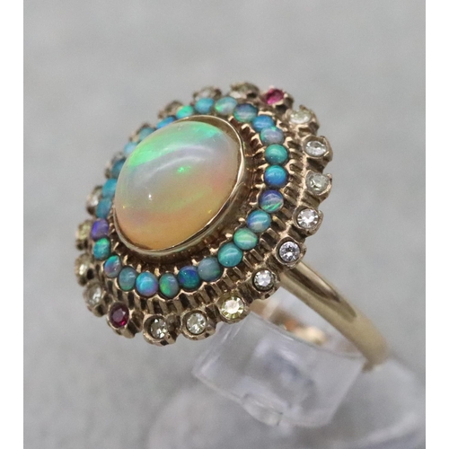 667 - A 14ct gold ladies' oval cluster ring set with centre opal surrounded by furthers opals with clear a... 