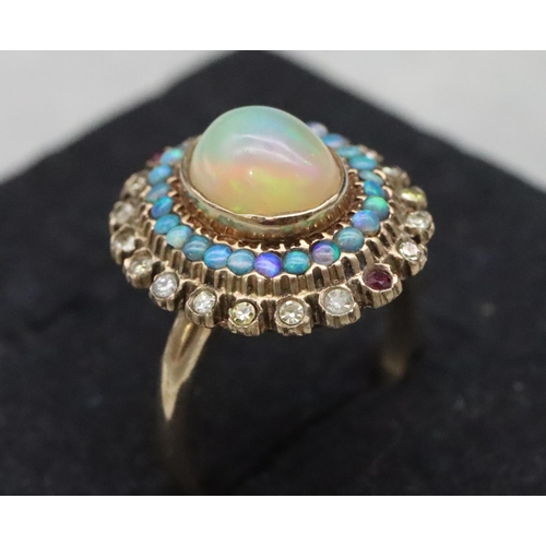 667 - A 14ct gold ladies' oval cluster ring set with centre opal surrounded by furthers opals with clear a... 