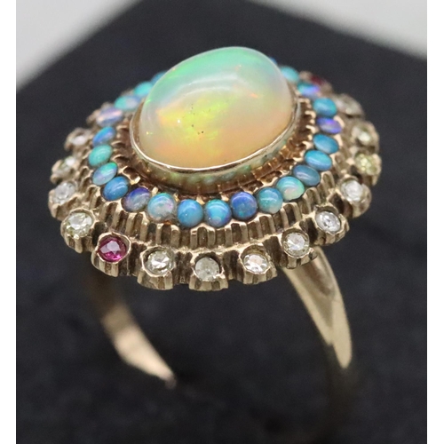 667 - A 14ct gold ladies' oval cluster ring set with centre opal surrounded by furthers opals with clear a... 