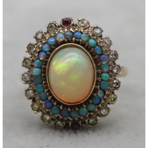 667 - A 14ct gold ladies' oval cluster ring set with centre opal surrounded by furthers opals with clear a... 