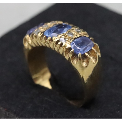 668 - An 18ct gold ring set with 3 pale sapphires interspersed with 6 small rough cut diamonds, Size S/T, ... 