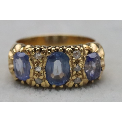 668 - An 18ct gold ring set with 3 pale sapphires interspersed with 6 small rough cut diamonds, Size S/T, ... 