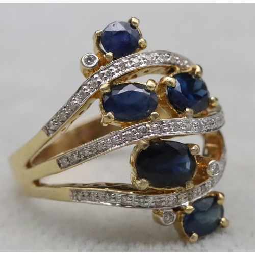 669 - An 18ct gold ladies' large cluster ring set with 5 sapphires interspersed with 3 rows of diamonds wi... 