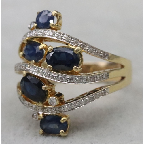 669 - An 18ct gold ladies' large cluster ring set with 5 sapphires interspersed with 3 rows of diamonds wi... 