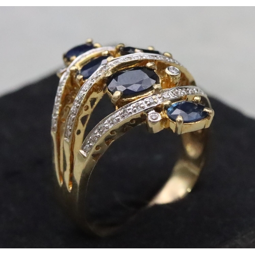 669 - An 18ct gold ladies' large cluster ring set with 5 sapphires interspersed with 3 rows of diamonds wi... 