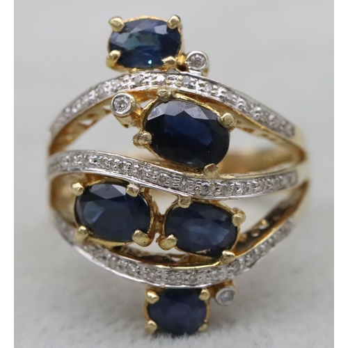 669 - An 18ct gold ladies' large cluster ring set with 5 sapphires interspersed with 3 rows of diamonds wi... 