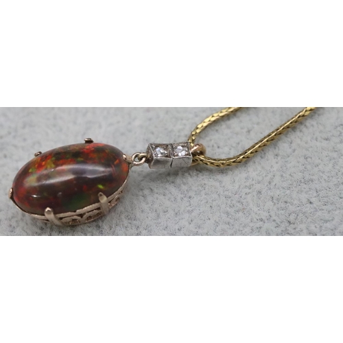 670 - A gold oval black opal drop pendant mounted with 2 small diamonds on high carat gold chain, 39.5cm l... 