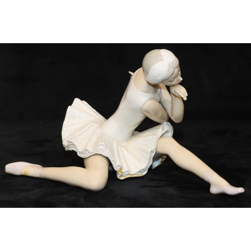 68 - A Lladro figure of a seated ballerina, 25cm long, 14cm high