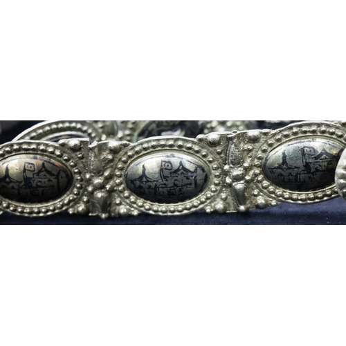 682 - An Eastern silver coloured panel bracelet with allover niello building decoration, 81cm long overall