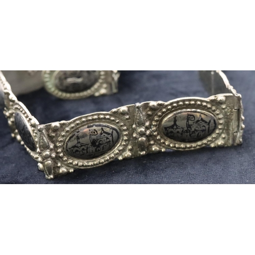 682 - An Eastern silver coloured panel bracelet with allover niello building decoration, 81cm long overall