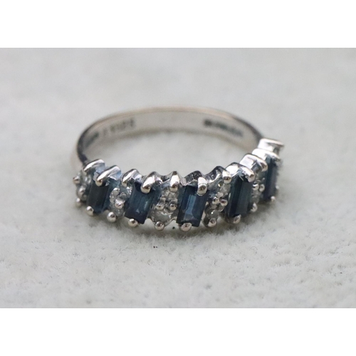 704 - An 18ct white gold ladies' half eternity ring set with baguette sapphires interspersed by small diam... 