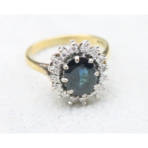 706 - An 18ct gold oval cluster ring set with centre sapphire surrounded by small diamonds, Size N, 5.3 gr... 