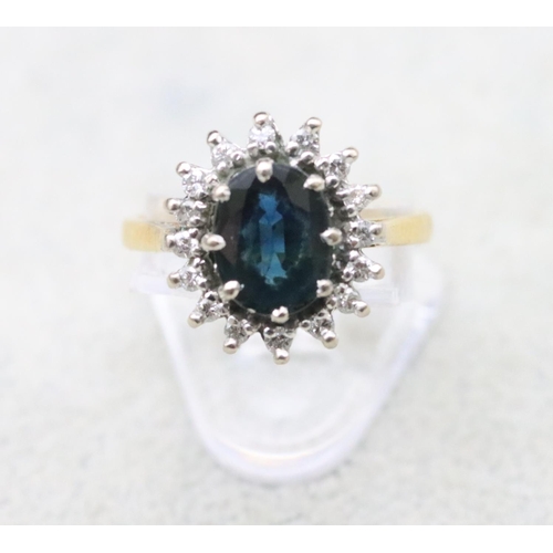 706 - An 18ct gold oval cluster ring set with centre sapphire surrounded by small diamonds, Size N, 5.3 gr... 