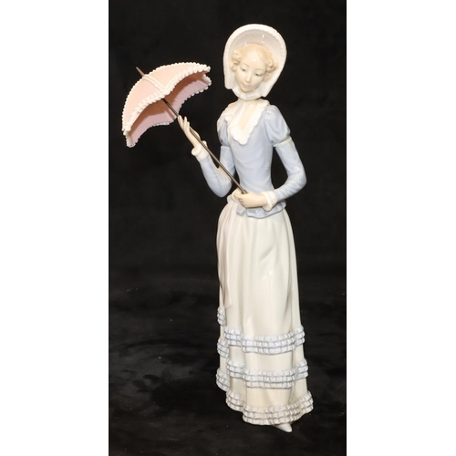 71 - A Lladro standing figure of a young lady holding a parasol, 32cm high