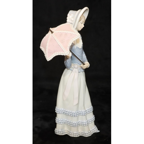 71 - A Lladro standing figure of a young lady holding a parasol, 32cm high