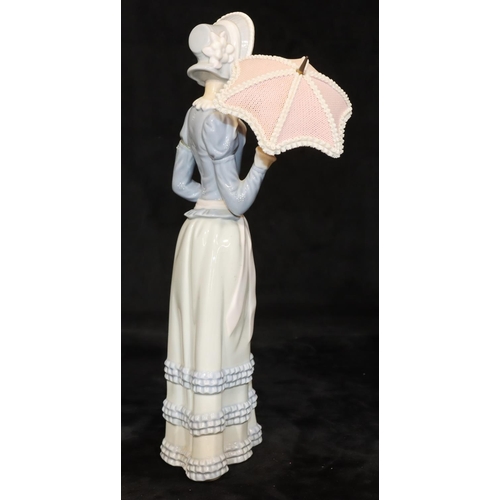 71 - A Lladro standing figure of a young lady holding a parasol, 32cm high