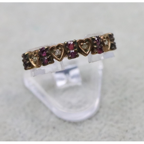 713 - A 9ct gold half eternity ring with 4 heart shaped motifs inset with small diamonds, interspersed by ... 