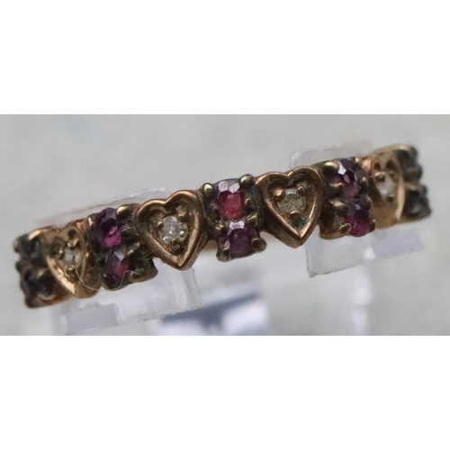 713 - A 9ct gold half eternity ring with 4 heart shaped motifs inset with small diamonds, interspersed by ... 