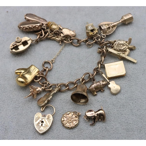 736 - A 9ct gold charm bracelet with padlock clasp, mounted with 16 gold charms (2 loose) and 1 small plat... 