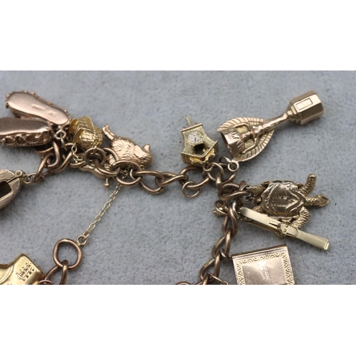 736 - A 9ct gold charm bracelet with padlock clasp, mounted with 16 gold charms (2 loose) and 1 small plat... 