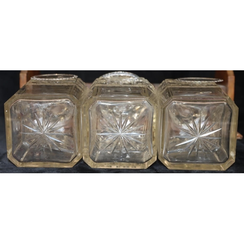 766 - An oak tantalus containing 3 square cut glass decanters (1 cracked and 2 chipped), with 3 silver pla... 