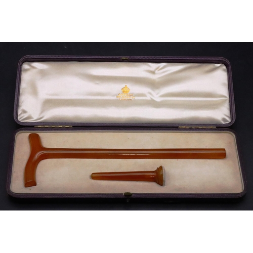 831 - An Asprey, London amber parasol handle and finial in fitted purple leather case, handle 24cm long