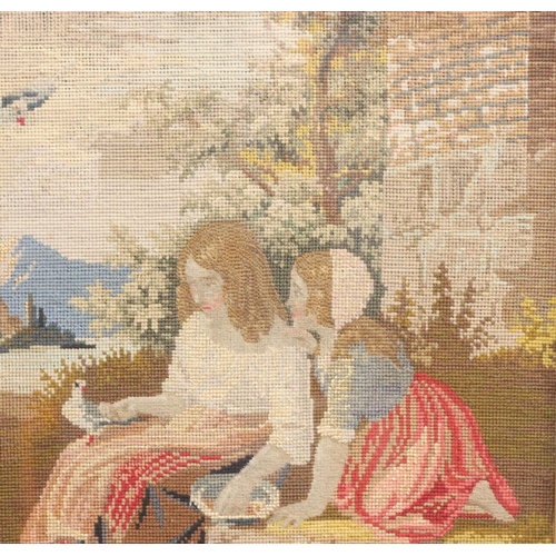 833 - A Woolwork picture depicting 2 seated girls with doves and river landscape with mountains in backgro... 