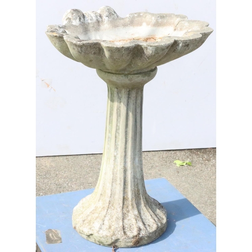 883 - A concrete garden bird bath with shell shaped bowl on round splayed base, 55cm wide, 70cm high