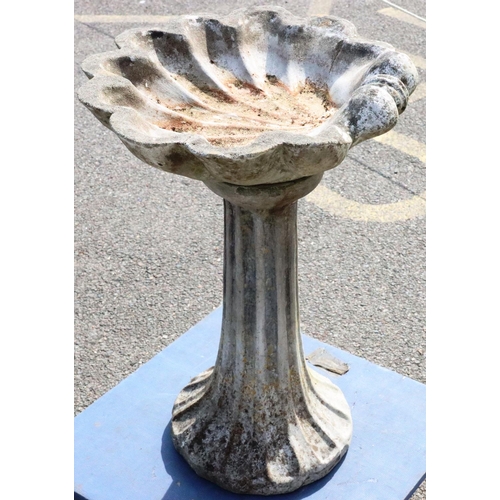 883 - A concrete garden bird bath with shell shaped bowl on round splayed base, 55cm wide, 70cm high