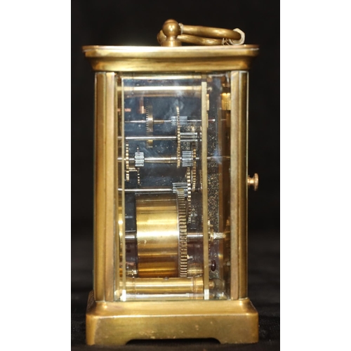 912 - A brass carriage clock with white enamel dial and Roman numerals, swing overhead handle, 11.5cm high... 