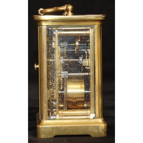 912 - A brass carriage clock with white enamel dial and Roman numerals, swing overhead handle, 11.5cm high... 