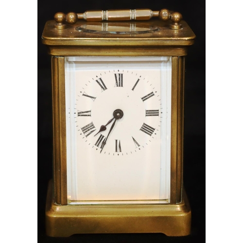 913 - A brass carriage clock with white enamel dial and Roman numerals, swing overhead handle, 12cm high, ... 