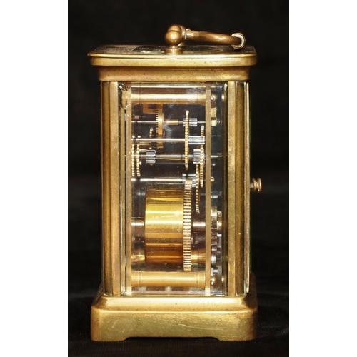 913 - A brass carriage clock with white enamel dial and Roman numerals, swing overhead handle, 12cm high, ... 