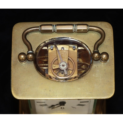 913 - A brass carriage clock with white enamel dial and Roman numerals, swing overhead handle, 12cm high, ... 