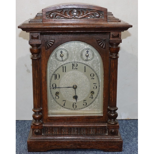 914 - Kienzle, German oak 8-day striking Westminster chime mantel clock with arched silvered dial and Arab... 