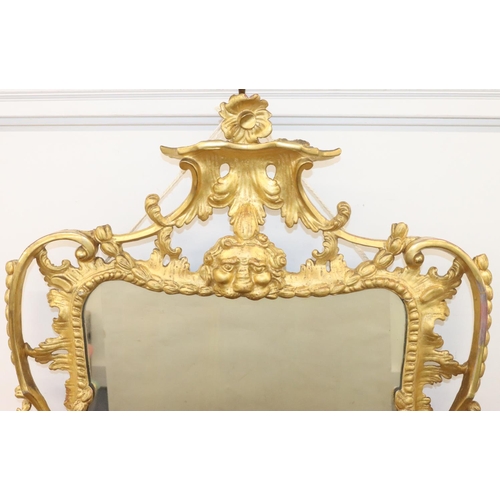 927 - A 19th Century carved giltwood wall mirror with raised animal head, floral, leaf and scroll decorati... 