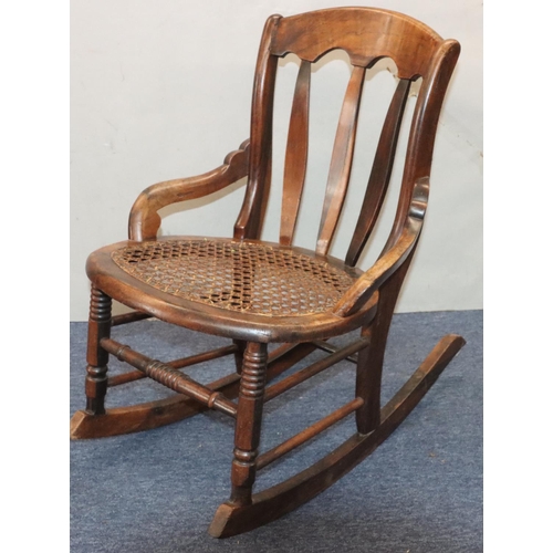 940 - A 19th Century mahogany small rocking nursing chair with cane seat ad splat back