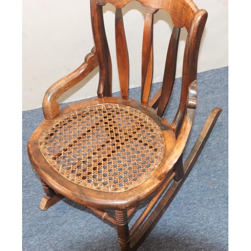 940 - A 19th Century mahogany small rocking nursing chair with cane seat ad splat back