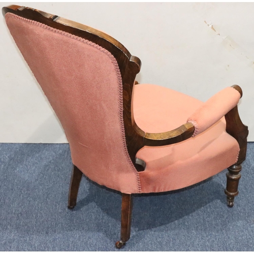 946 - A Victorian walnut armchair with pink velvet overstuffed seat, button back and padded arms.