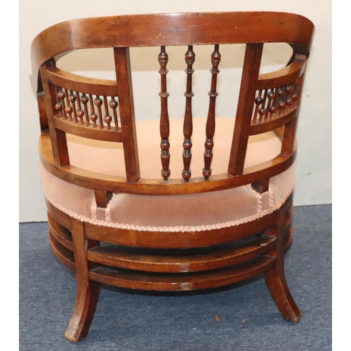 952 - A mahogany low tub nursing chair with spindle back, velvet overstuffed seat, on splayed legs