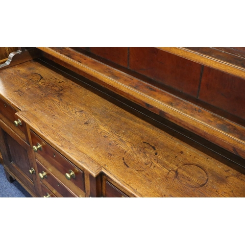 954 - A George III oak and mahogany breakfront Welsh dresser with shelfed back, 4 graduated centre drawers... 