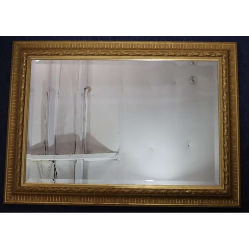 955 - A modern gilt hanging bevelled wall mirror with raised and fluted rim, 91.5cm x 66cm