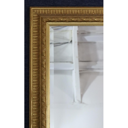 955 - A modern gilt hanging bevelled wall mirror with raised and fluted rim, 91.5cm x 66cm